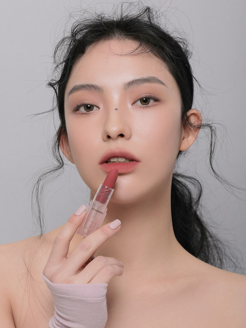 Model applying 3CE Soft Matte Lipstick in Shade Chill Move, showcasing its velvety texture and smooth matte finish.