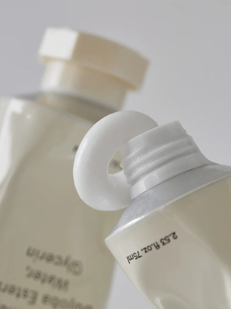 Close-up of two Abib Jericho Rose Crème tubes with white caps; one nozzle visible, showcasing matte and glossy textures under soft lighting.