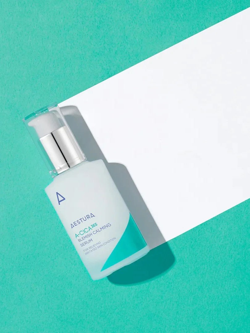 A bottle of Aestura A-Cica 365 Blemish Calming Serum on a vibrant turquoise background, next to a white paper sheet.