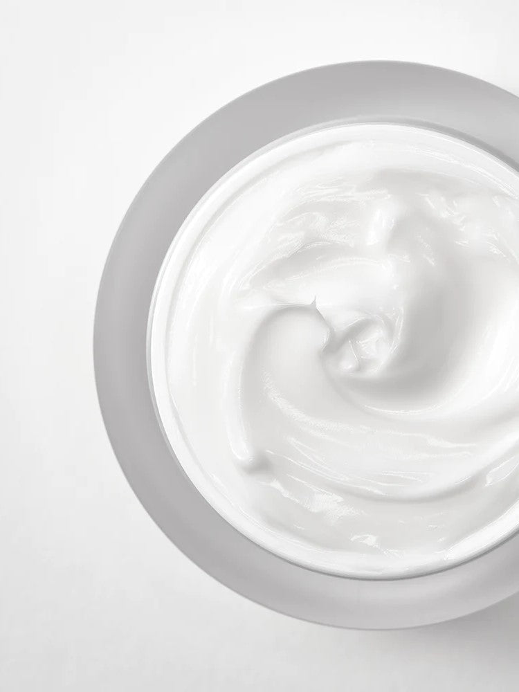 A close-up view of the smooth, creamy white texture of Anua Heartleaf Intense Calming Cream on a light background.