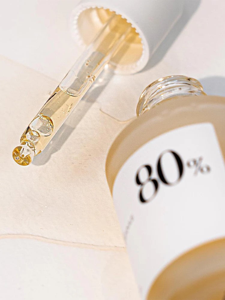 Close-up of the Anua Heartleaf Soothing Ampoule with a dropper tip, showcasing its texture on a white surface.