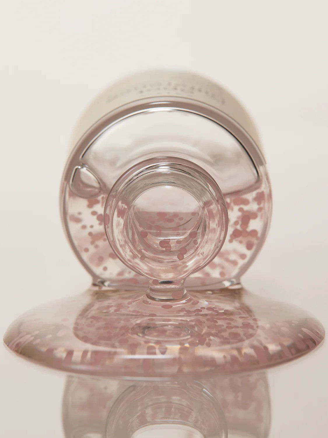 Close-up of Axis-Y Spot Difference Blemish Treatment dispensing light gel texture with hydrating Ceramide capsules against a neutral background.