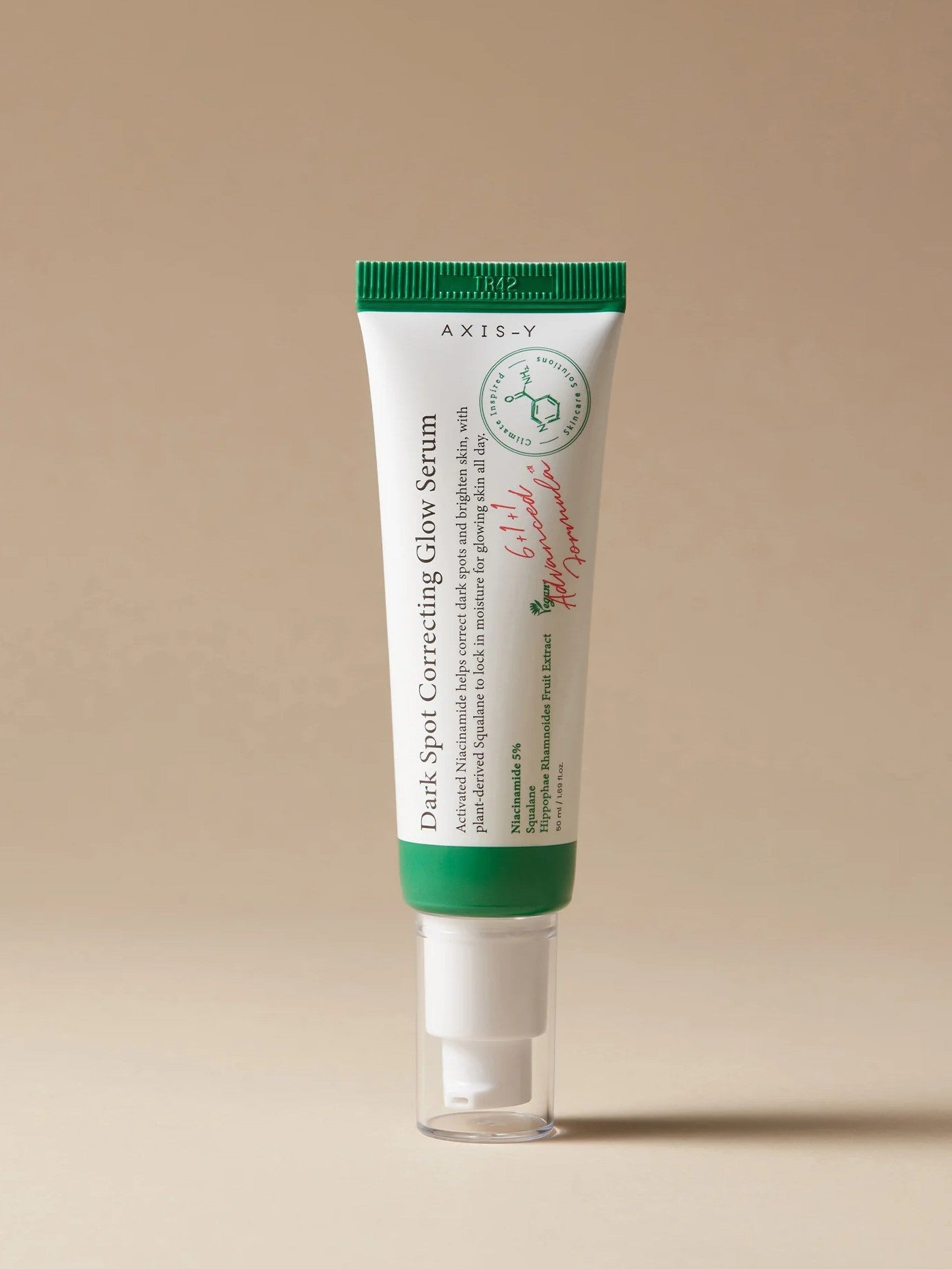 A tube of Axis-Y Dark Spot Correcting Glow Serum with a green cap, set against a neutral background.