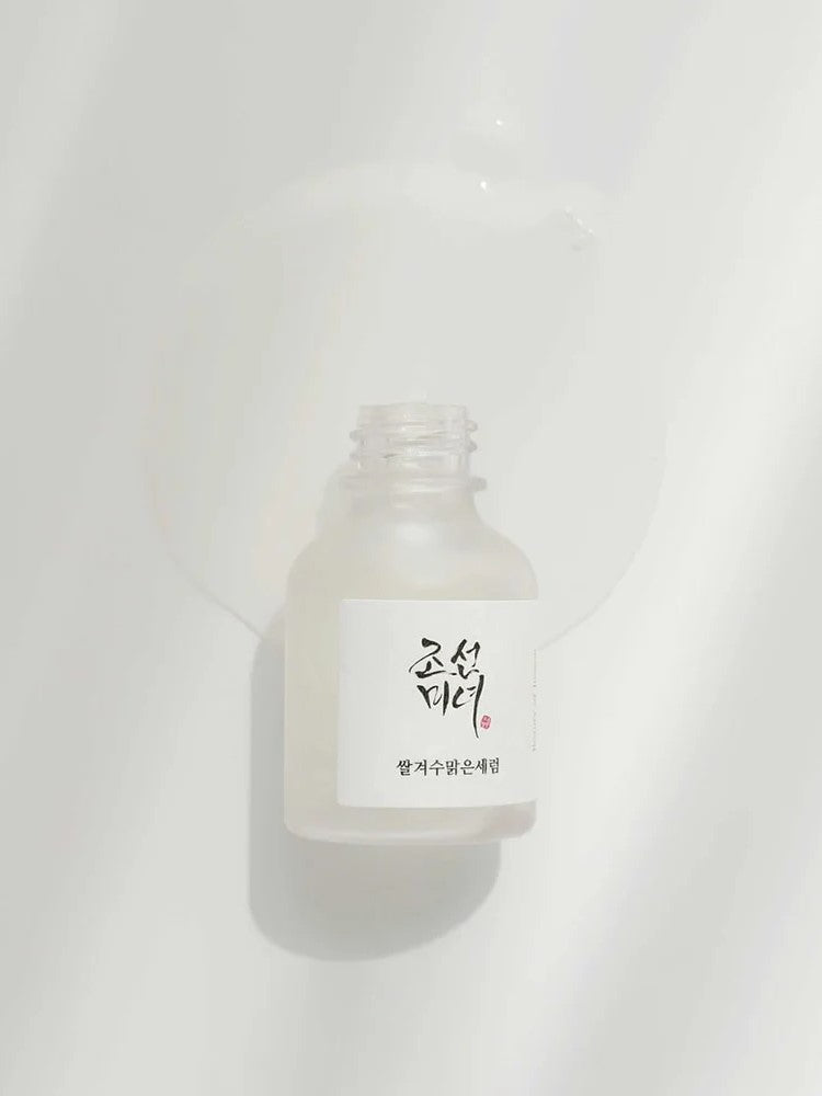 Beauty of Joseon Glow Deep Serum: Rice and Alpha Arbutin with liquid flowing out, showcasing its lightweight texture against a soft white background.