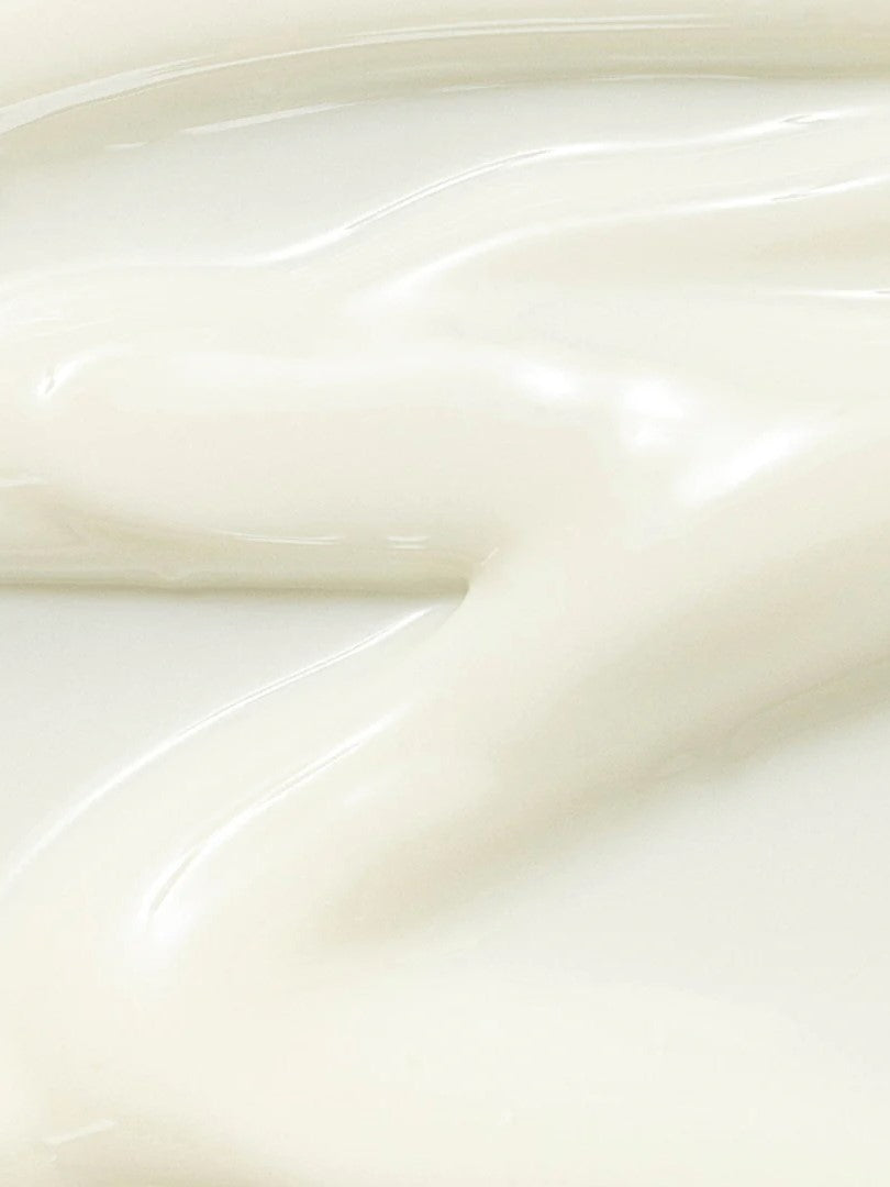 Close-up of 'Beauty of Joseon Relief Sun: Rice + Probiotics' creamy and lightweight texture flowing on a plain surface, showcasing its nourishing formula.
