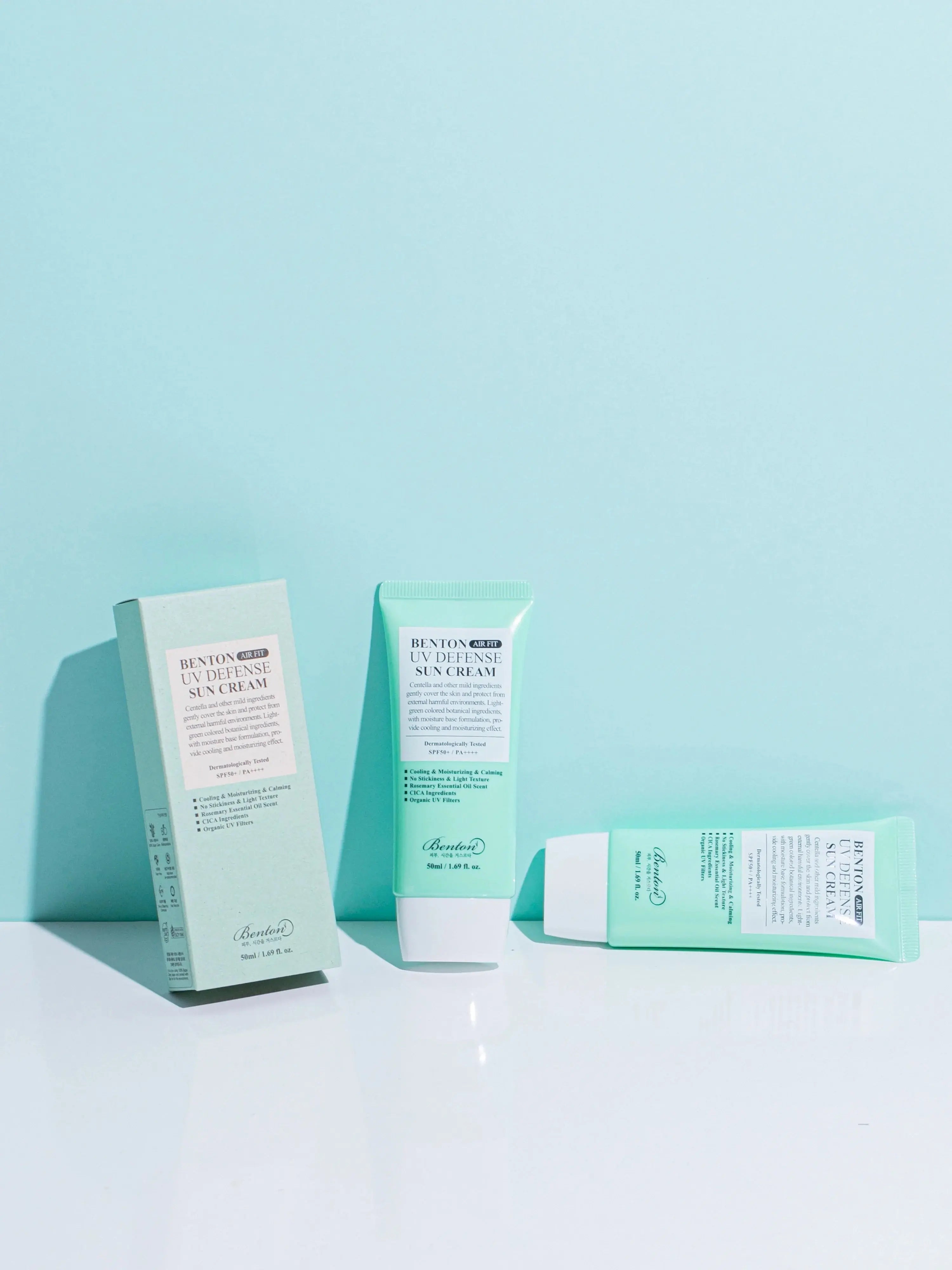 Three Benton Air Fit UV Defense Sun Cream tubes displayed on a blue background, showcasing the packaging design.