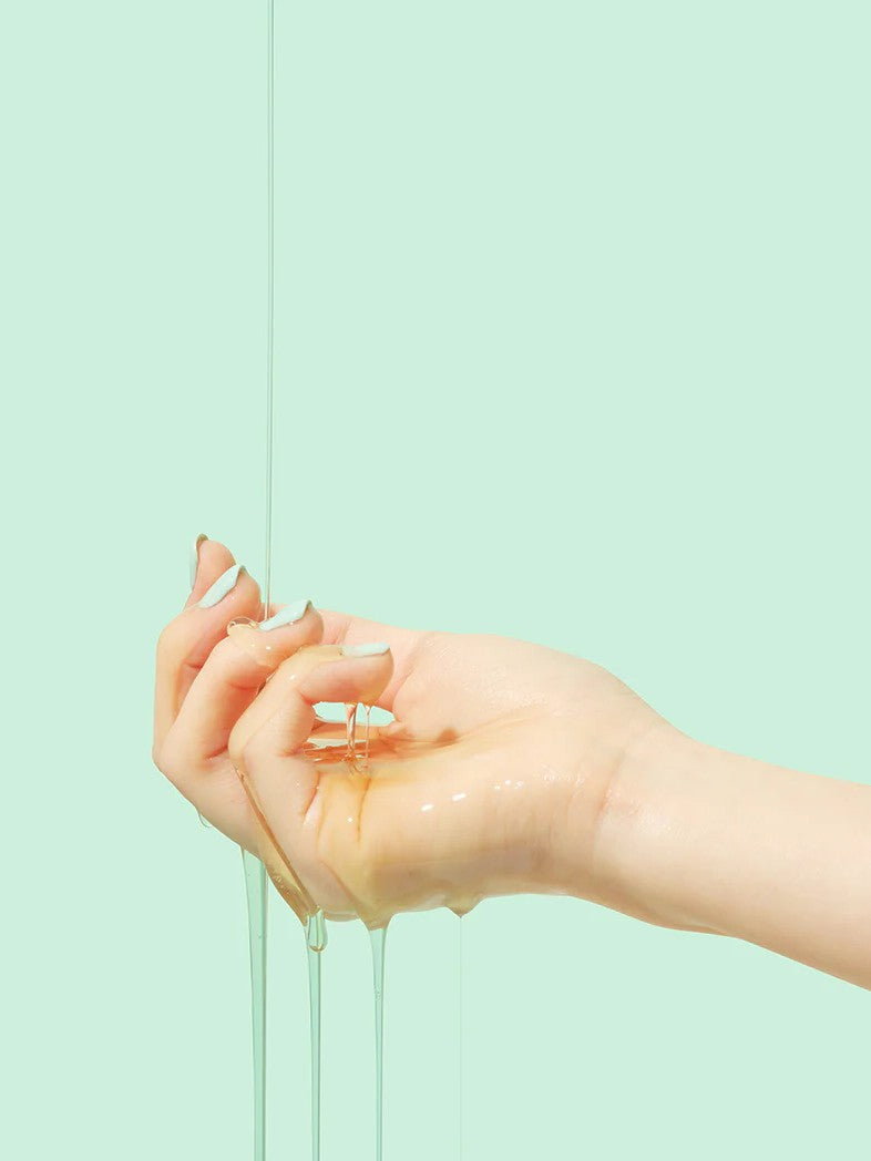 Close-up of Beplain Cicaterol Ampoule’s glossy texture dripping from a hand against a pale mint green background.