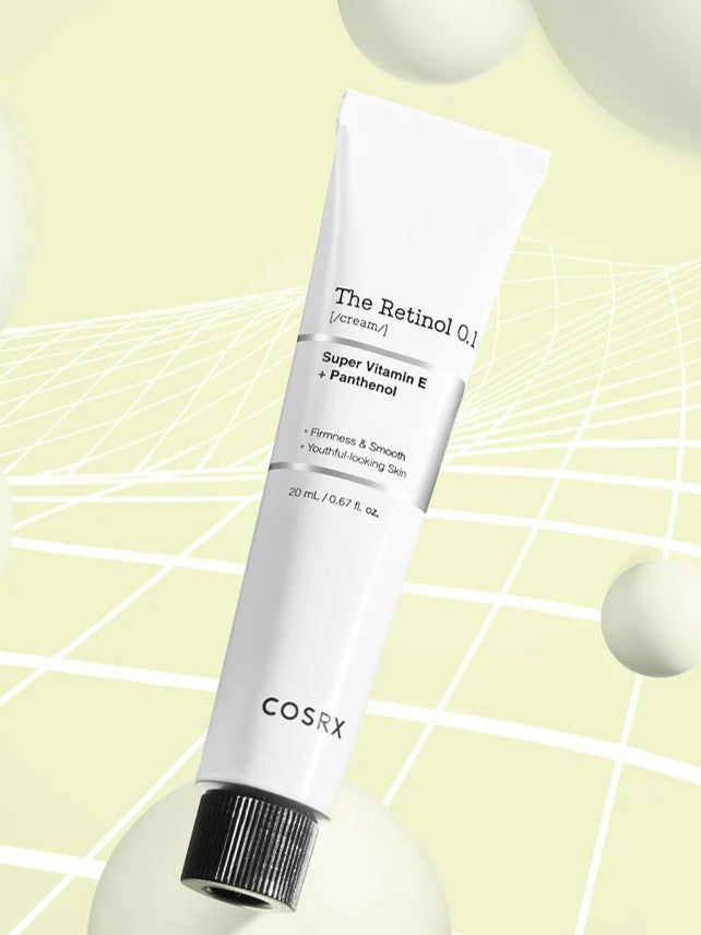 A tube of Cosrx Retinol 0.1 Cream on a soft yellow background, with Vitamin E and Panthenol highlighted on its label to promote youthful-looking skin.