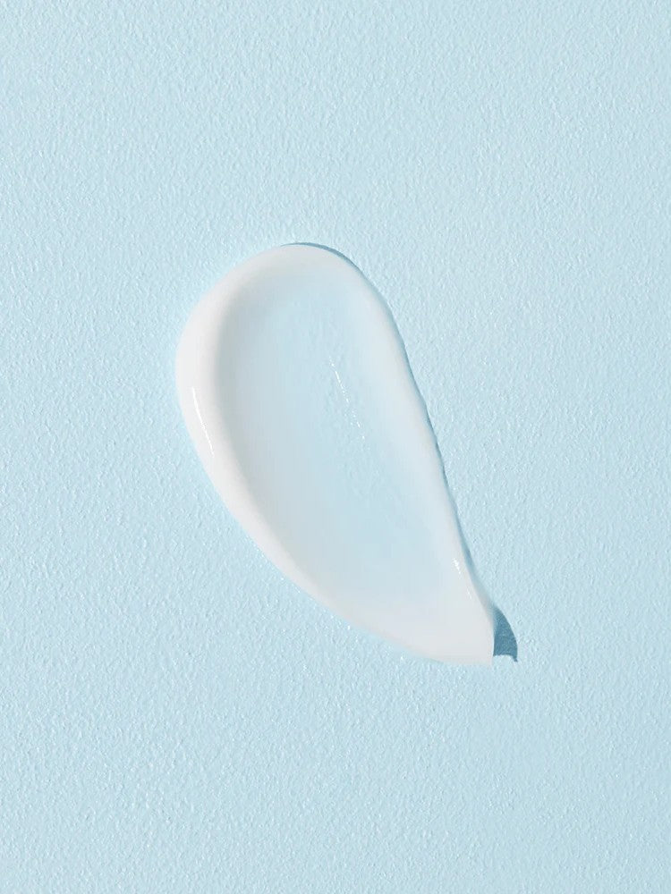 A smooth, glistening white cream droplet on a soft blue background, showcasing the texture of Cosrx Ultimate Nourishing Rice Overnight Spa Mask.