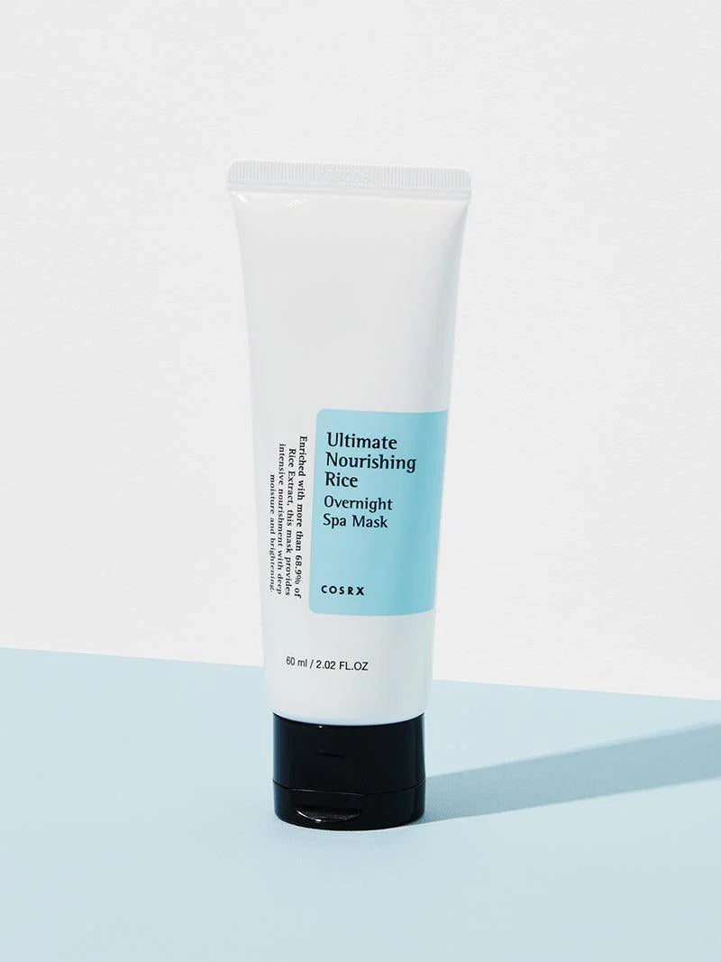 Cosrx Ultimate Nourishing Rice Overnight Spa Mask in a white tube with blue label, resting on a light blue background.