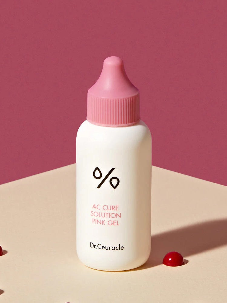 A bottle of Dr. Ceuracle AC Cure Solution Pink Gel on a beige surface, formulated with soothing and acne-targeting properties to address spot concerns effectively.