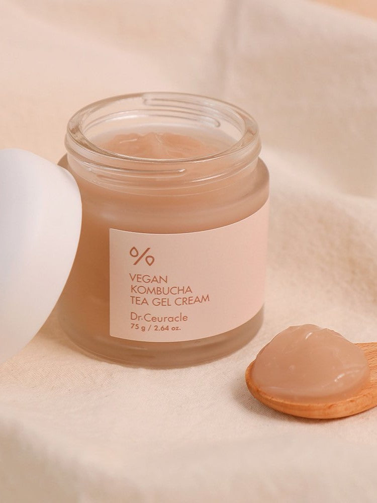 A jar of Dr. Ceuracle Vegan Kombucha Tea Gel Cream with a wooden scoop holding a dollop of its translucent, lightweight gel texture.