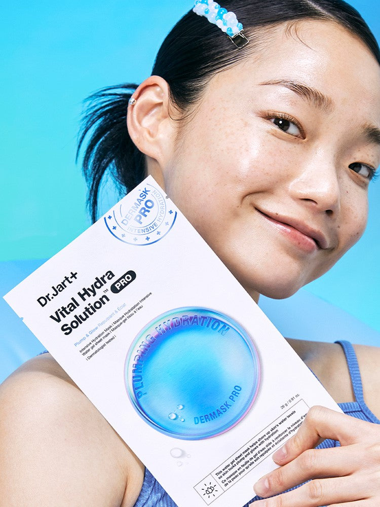 A model holding a Dr. Jart+ Dermask Vital Hydra Solution Pro mask against a blue background, emphasizing its hydration benefits.