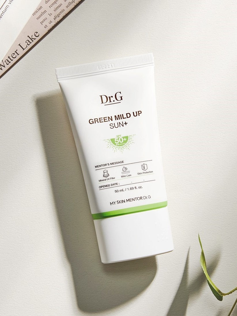 Dr.G Green Mild Up Sun+ Sunscreen SPF 50+ tube on a light surface, showing its white design with green accents and labeled details.