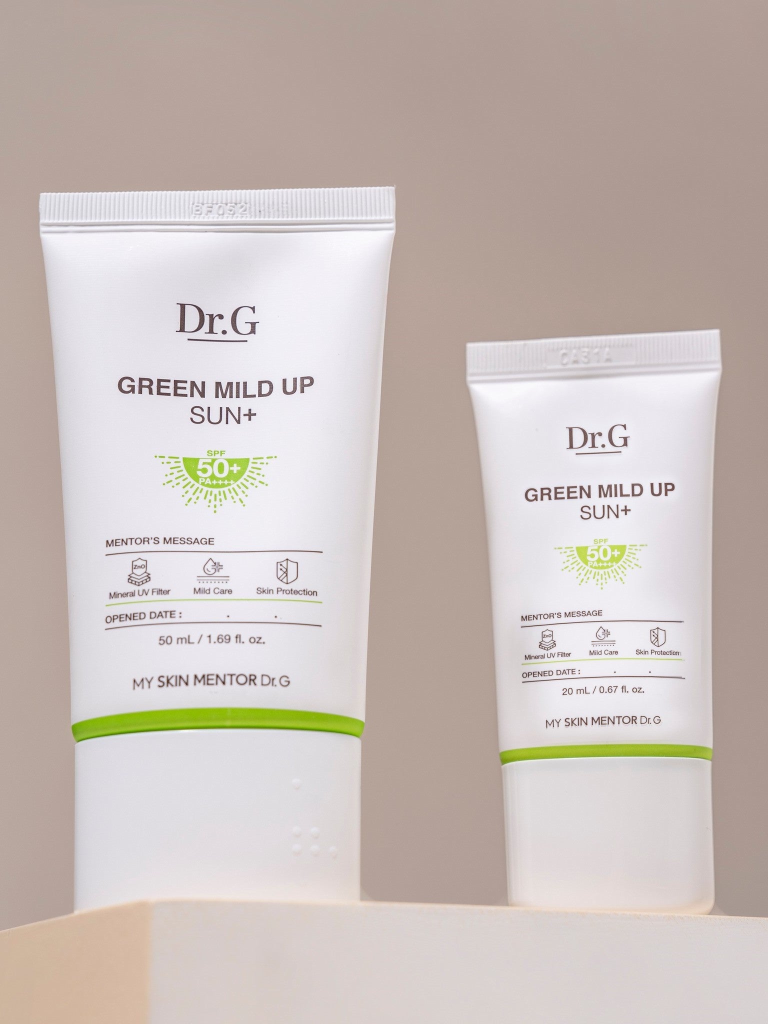 Two tubes of Dr.G Green Mild Up Sun+ Sunscreen labeled with SPF 50+, displayed side by side against a neutral background.