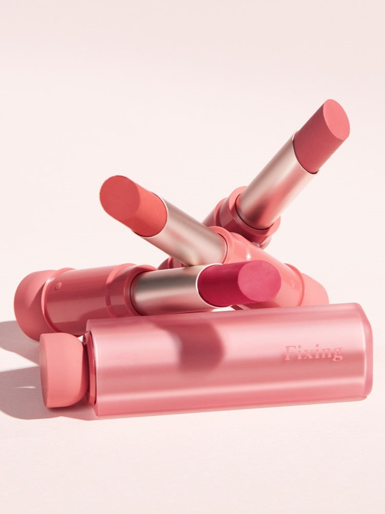 A vibrant arrangement of four pink lipsticks from the Etude House Fixing Tint Bar collection, set against a soft pastel background.