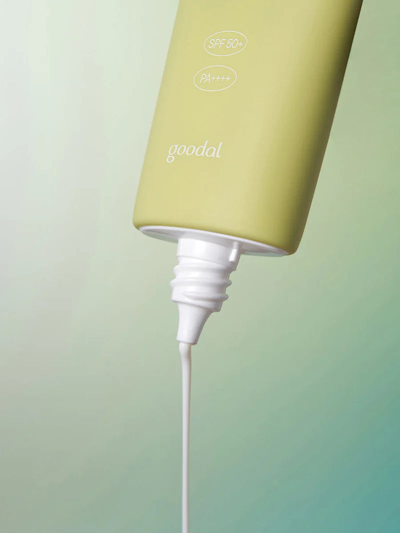 A tube of Goodal Houttuynia Cordata Calming Moisture Sun Cream with SPF 50+ and PA++++ dispensing its creamy white formula against a soft gradient background.