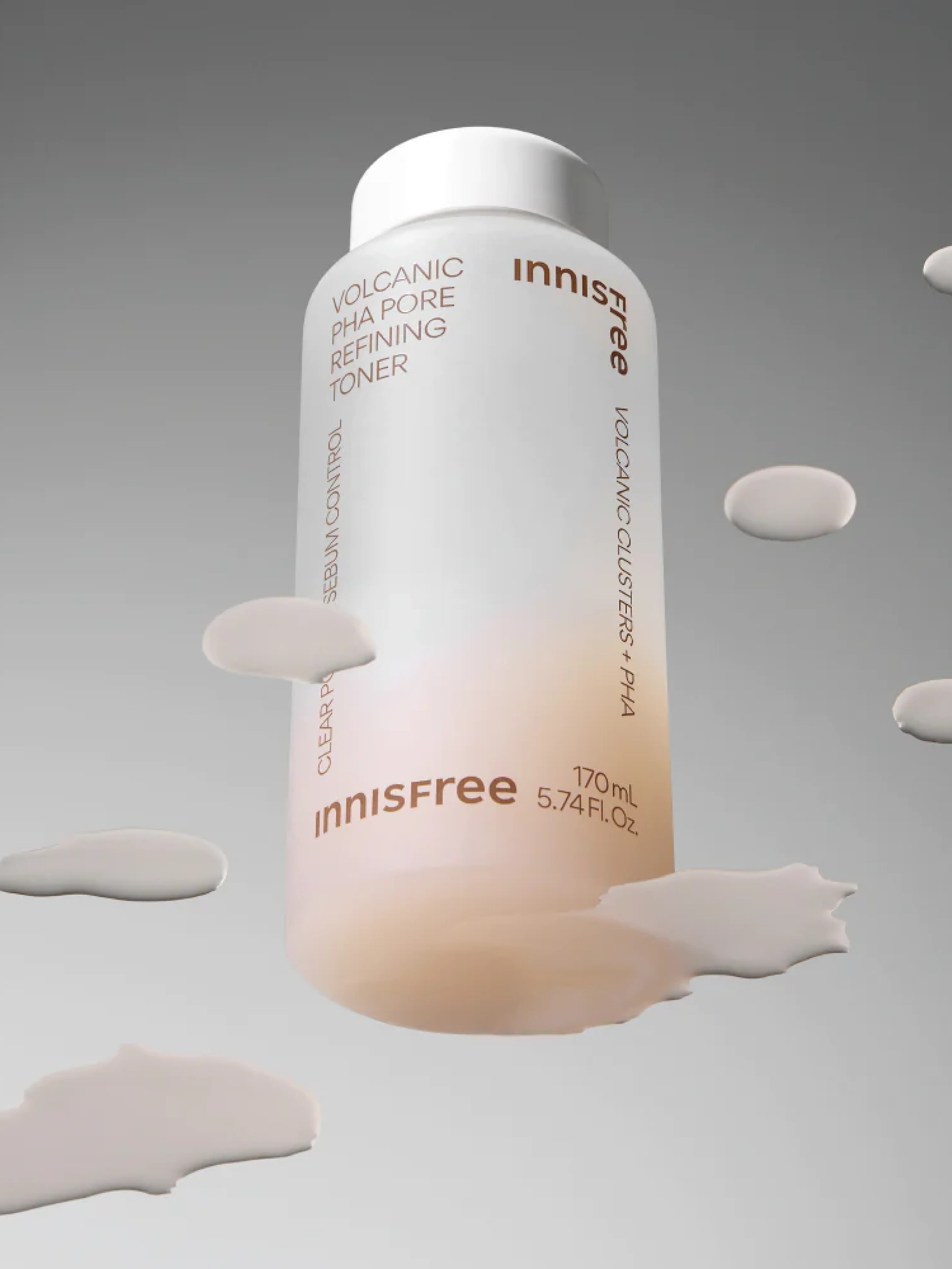 A bottle of Innisfree Volcanic PHA Pore Refining Toner with a white cap, surrounded by its lightweight texture drips against a gradient gray background, emphasizing its refining and sebum-controlling properties.