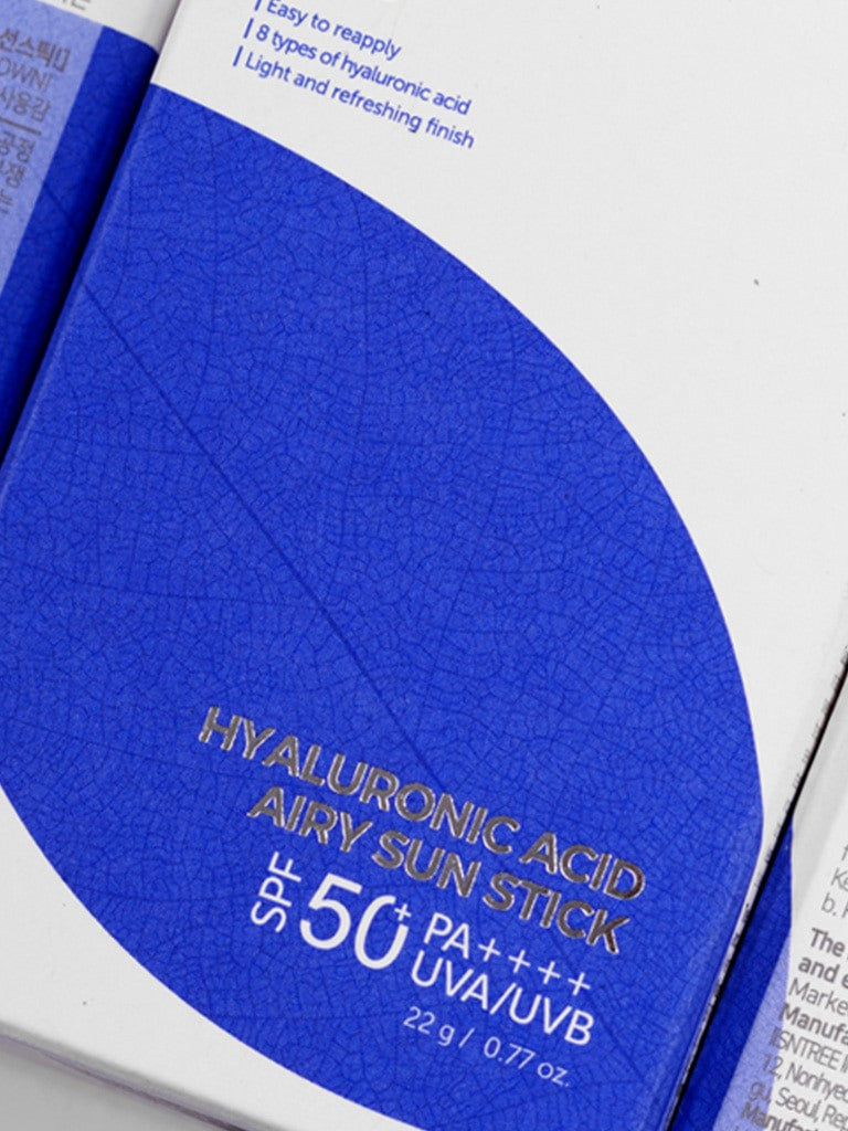 Close-up of the Isntree Hyaluronic Acid Airy Sun Stick packaging with SPF 50+, featuring blue design elements and key benefits listed.