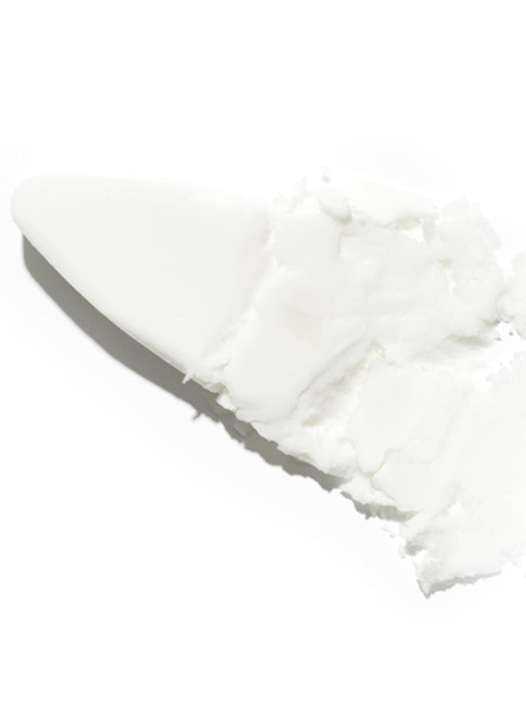 Creamy, buttery texture of Isntree Hyaluronic Acid Airy Sun Stick smeared with a spatula, showcasing its smooth and thick consistency against a plain background.