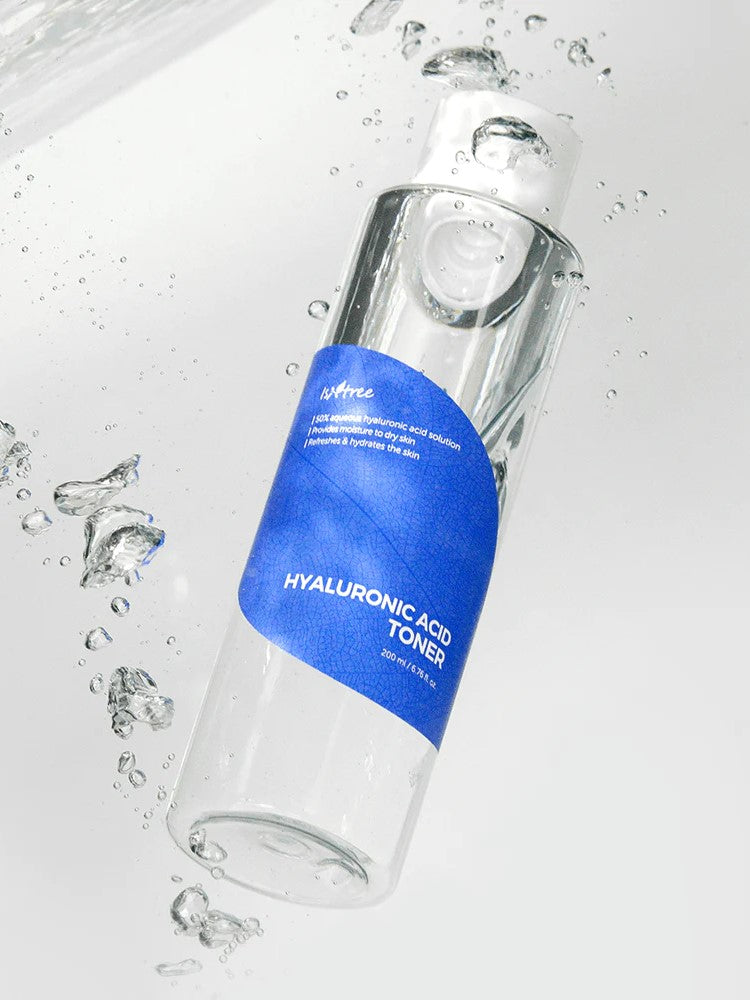 Isntree Hyaluronic Acid Toner with a blue label, surrounded by water droplets on a light backdrop, emphasizing its hydrating properties.