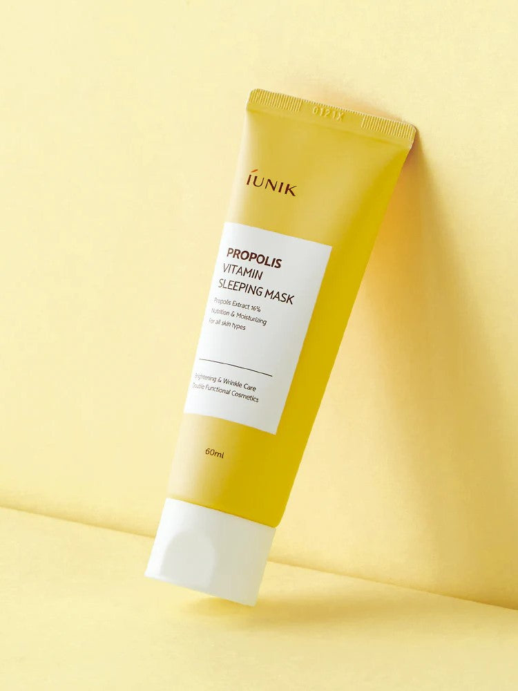 A yellow tube of iUNIK Propolis Vitamin Sleeping Mask against a soft yellow background, promoting hydration and nourishment for all skin types.