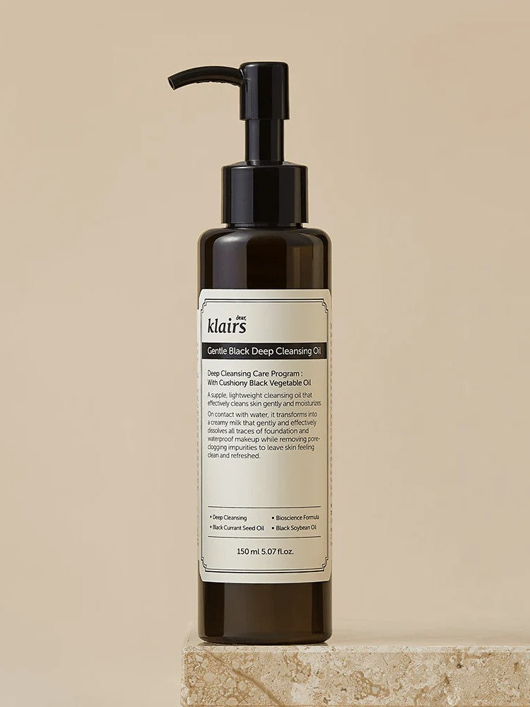 Dark bottle of Klairs Gentle Black Deep Cleansing Oil on a textured stone surface, featuring a pump top and product label, showcasing its deep cleansing properties.