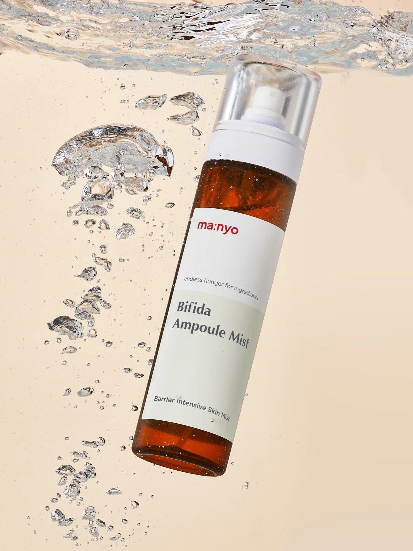Bottle of Manyo Bifida Ampoule Mist floating in water with droplets, emphasizing its barrier-strengthening and hydrating benefits.