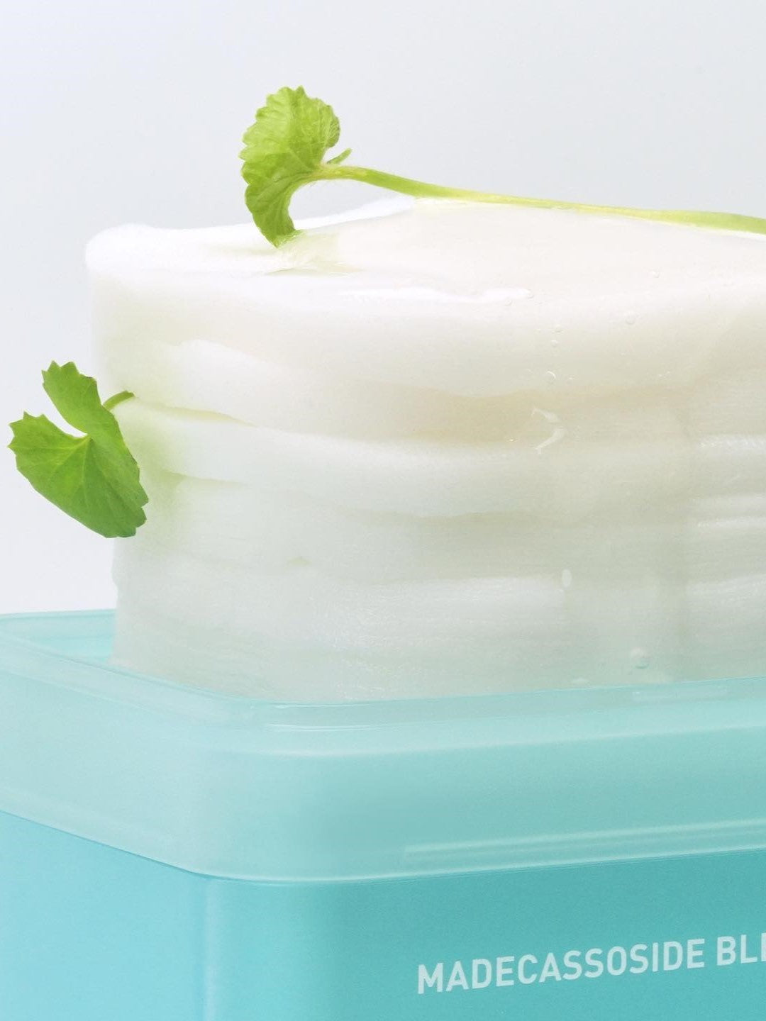 Mediheal Madecassoside Blemish Pads topped with a fresh Centella Asiatica leaf, emphasizing their calming and soothing benefits.