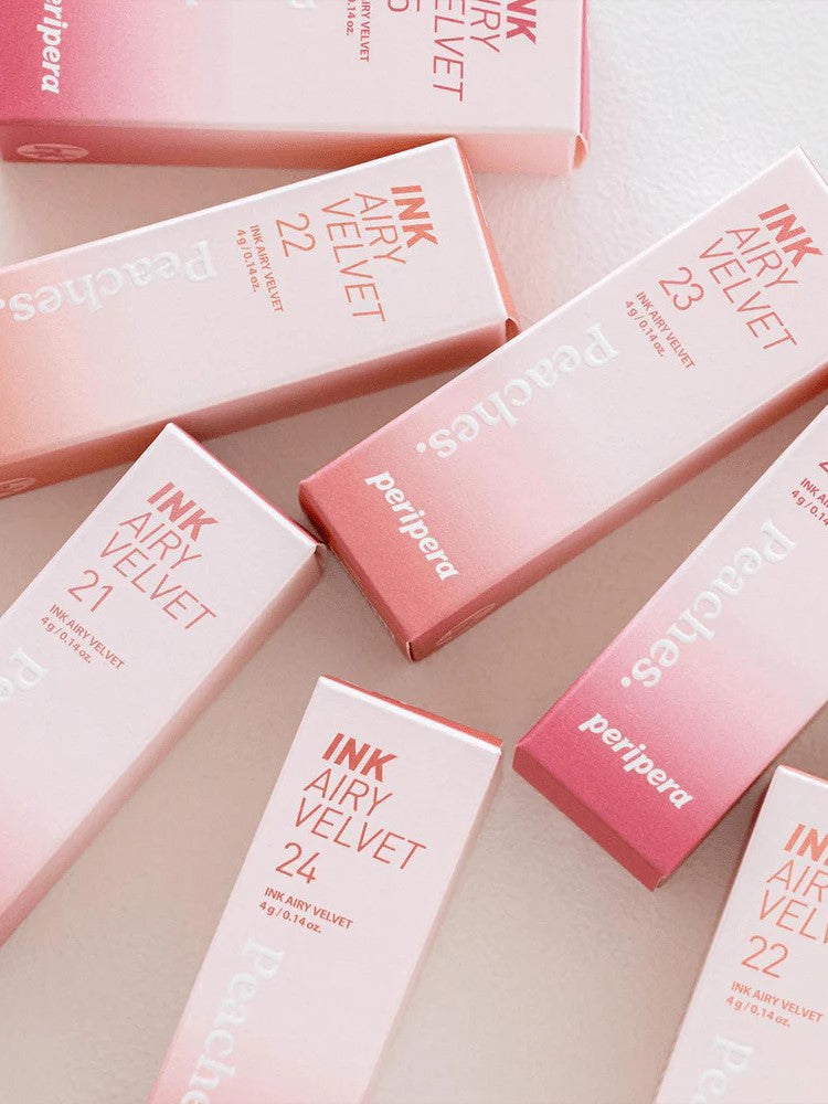 Flat lay of Peripera Ink Airy Velvet lip tint packaging in soft pink hues, featuring shades 21, 22, 23, and 24.