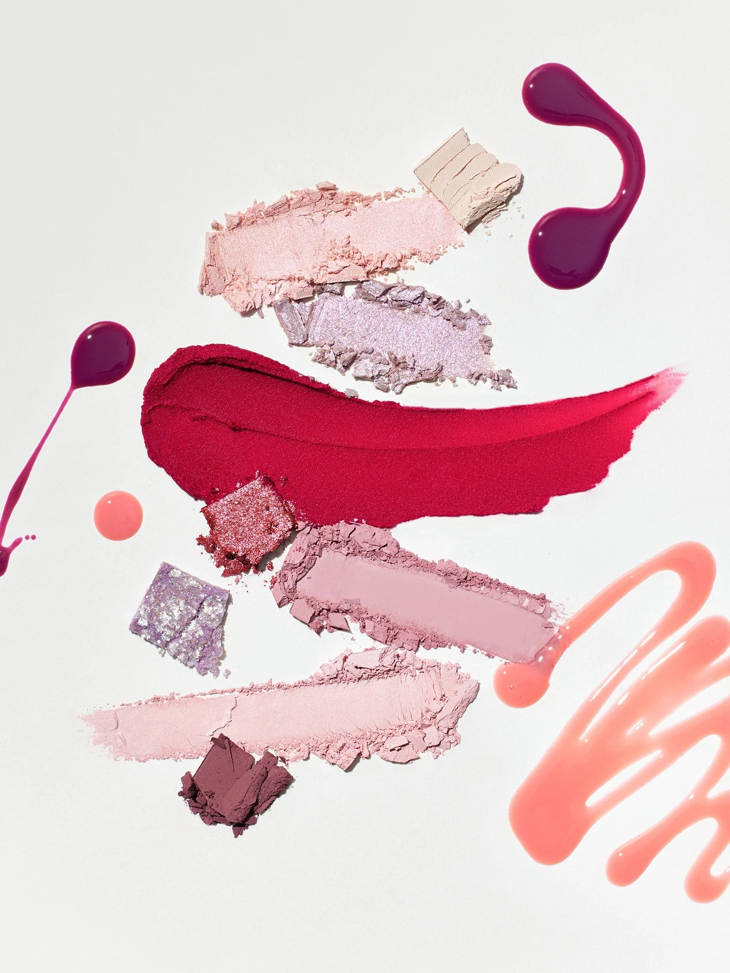Artistic arrangement of pink, red, and purple makeup pigments from the Romand Better Than Palette Energetic Series in 'Berry Fuchsia Garden,' set against a clean white background.