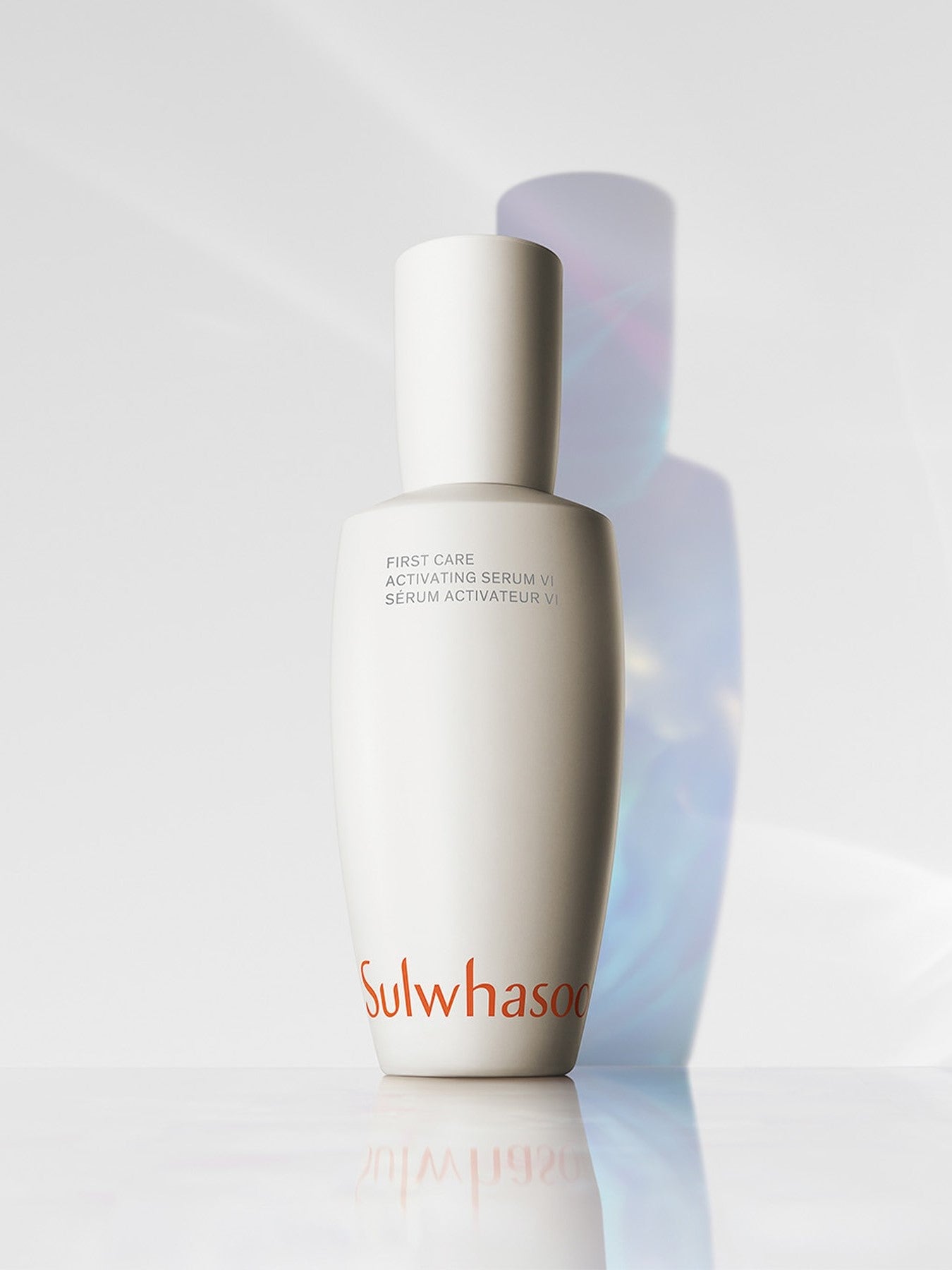 A sleek white bottle of Sulwhasoo First Care Activating Serum VI, elegantly reflecting light with soft shadows on a bright surface.