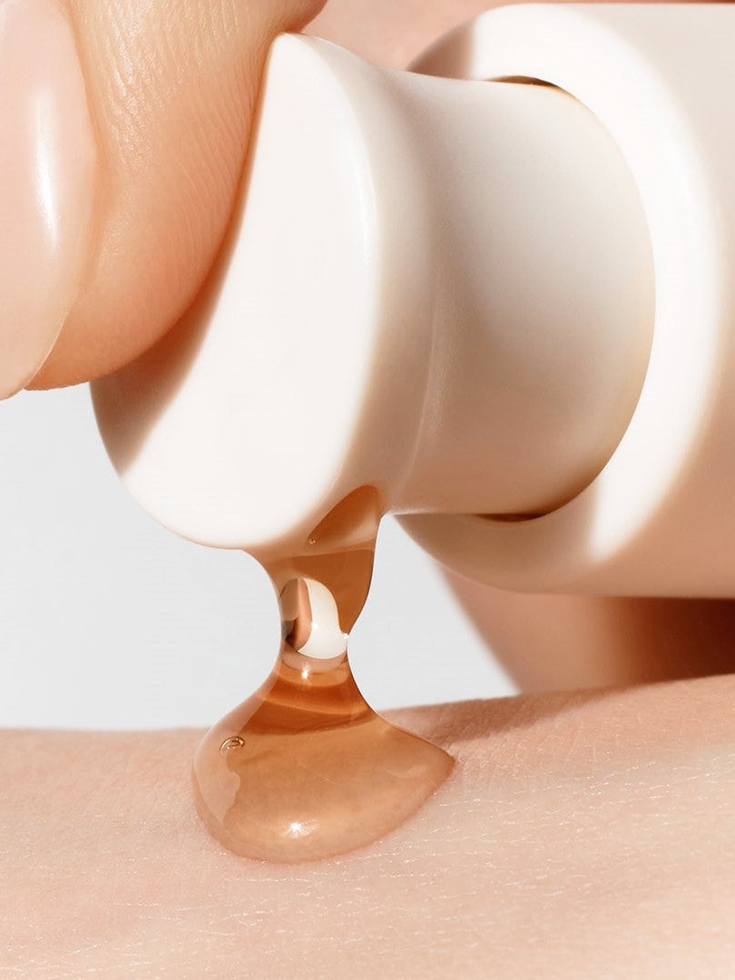 A droplet of Sulwhasoo First Care Activating Serum VI being dispensed onto a person’s skin, highlighting its smooth texture.