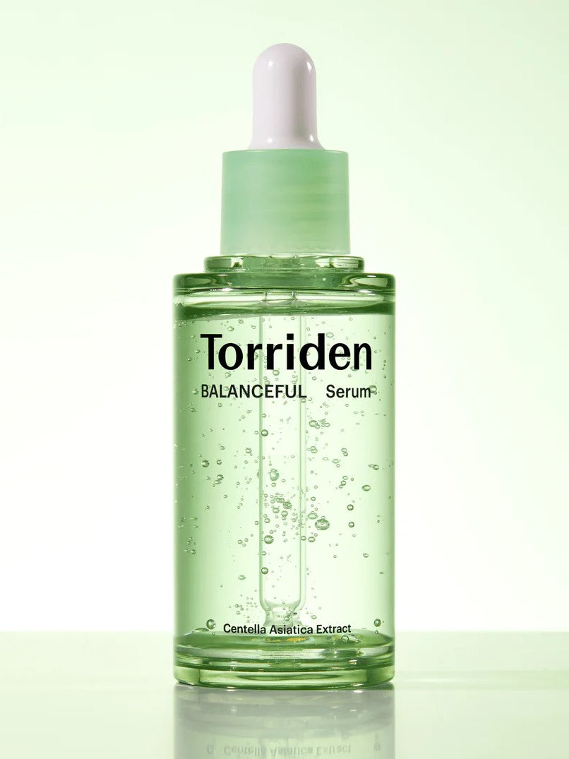 Green glass dropper bottle of Torriden's Balanceful Serum with visible bubbles, highlighting 'Centella Asiatica Extract' as a key ingredient on the label.