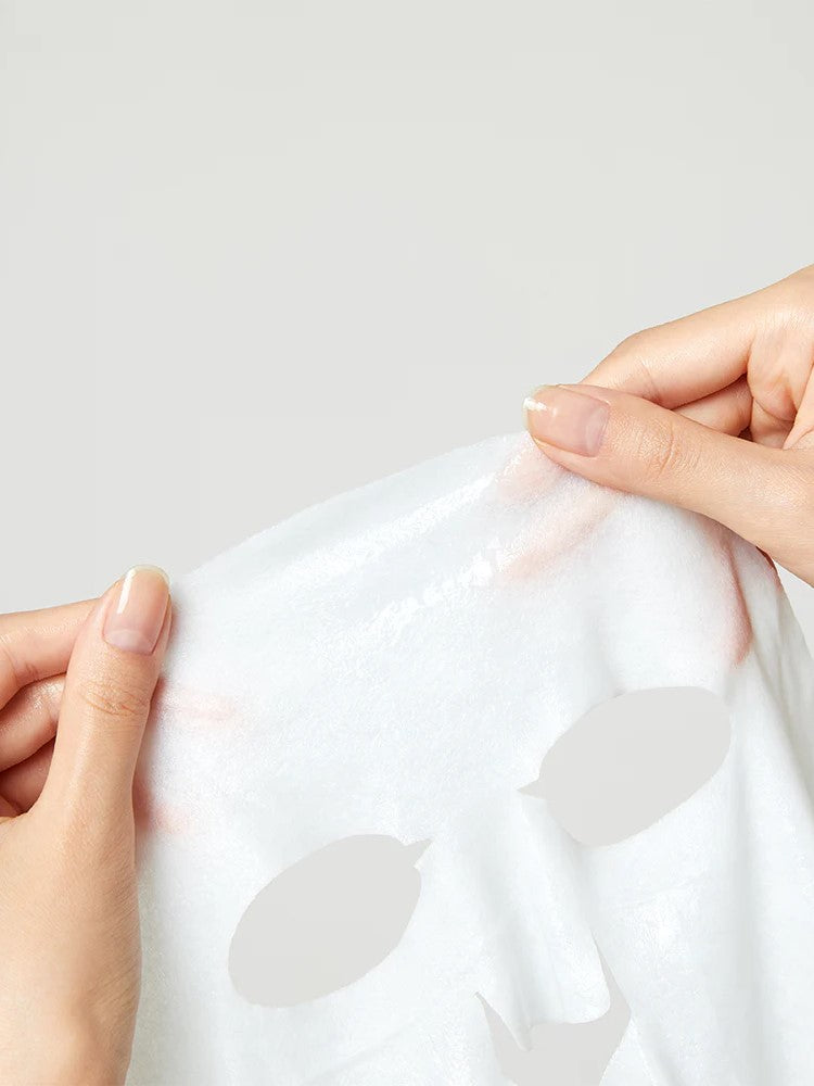 Pair of hands holding Torriden Dive In Mask sheet mask, showcasing its texture against a neutral background.