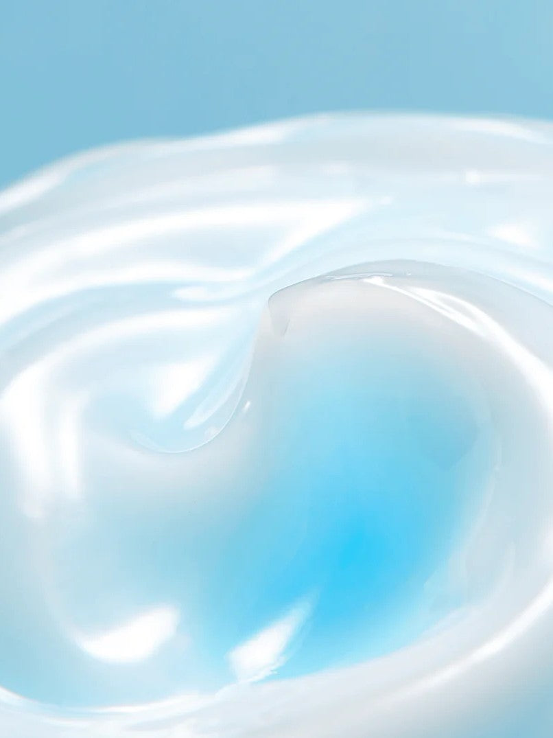 Close-up of smooth, glossy blue-tinted Torriden Dive In Soothing Cream against a light blue background, showcasing its swirling texture.