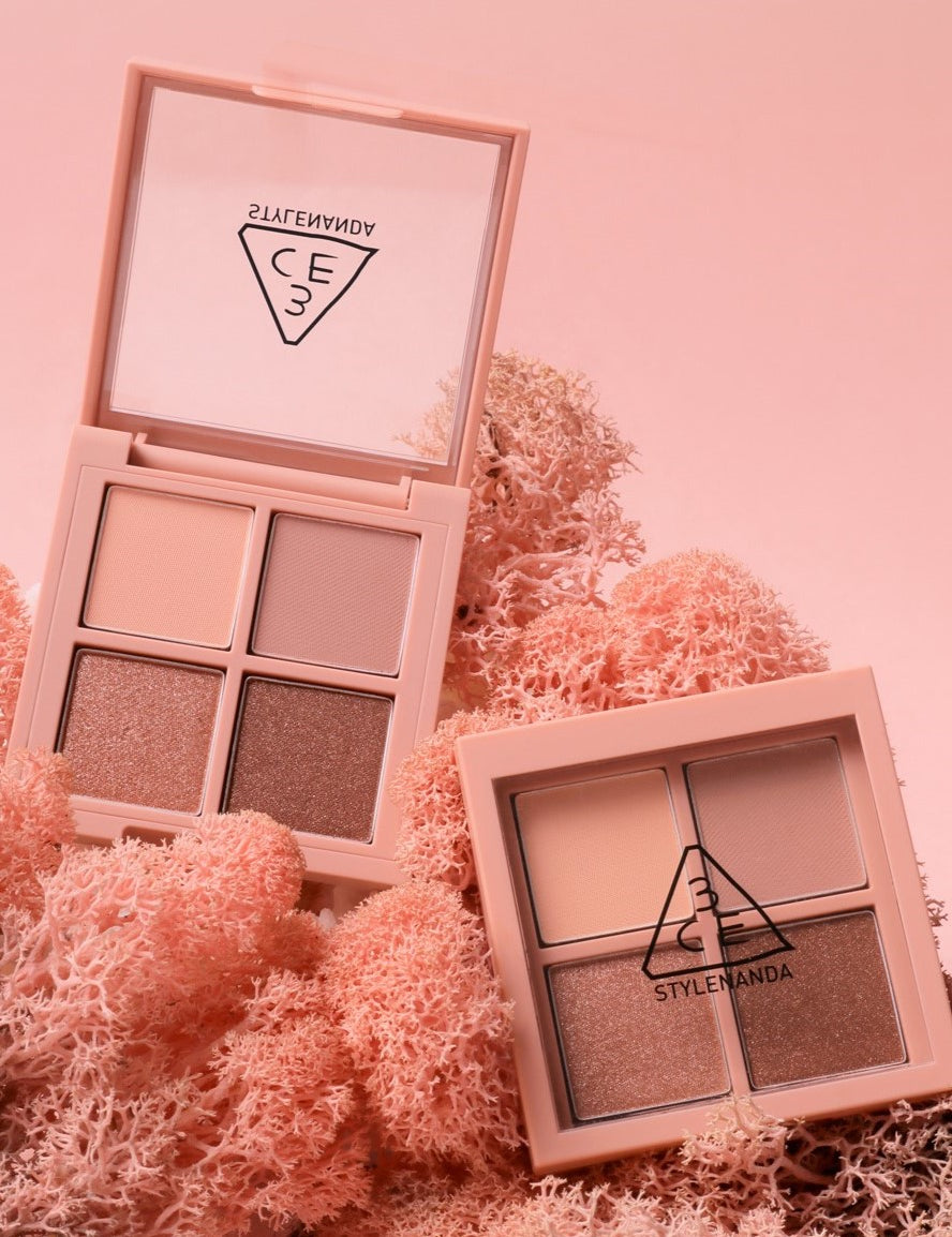 Two 3CE Mini Multi Eye Color Palette eyeshadows displayed on pink coral background, showcasing neutral and shimmering shades.