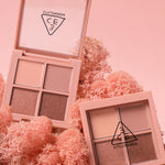 Two 3CE Mini Multi Eye Color Palette eyeshadows displayed on pink coral background, showcasing neutral and shimmering shades.