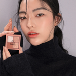 Model in black turtleneck holding 3CE Mini Multi Eye Color Palette in Shade Second Pair, showcasing wearable versatility.