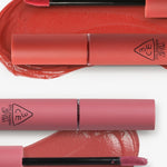 Two 3CE Velvet Lip Tint tubes with applicators placed over vibrant coral and pink swatches, showcasing smooth texture and rich pigmentation.