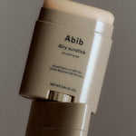 Close-up of the Abib Airy Sunstick, a waterproof SPF 50+ sunscreen stick in sleek taupe packaging designed for easy application.