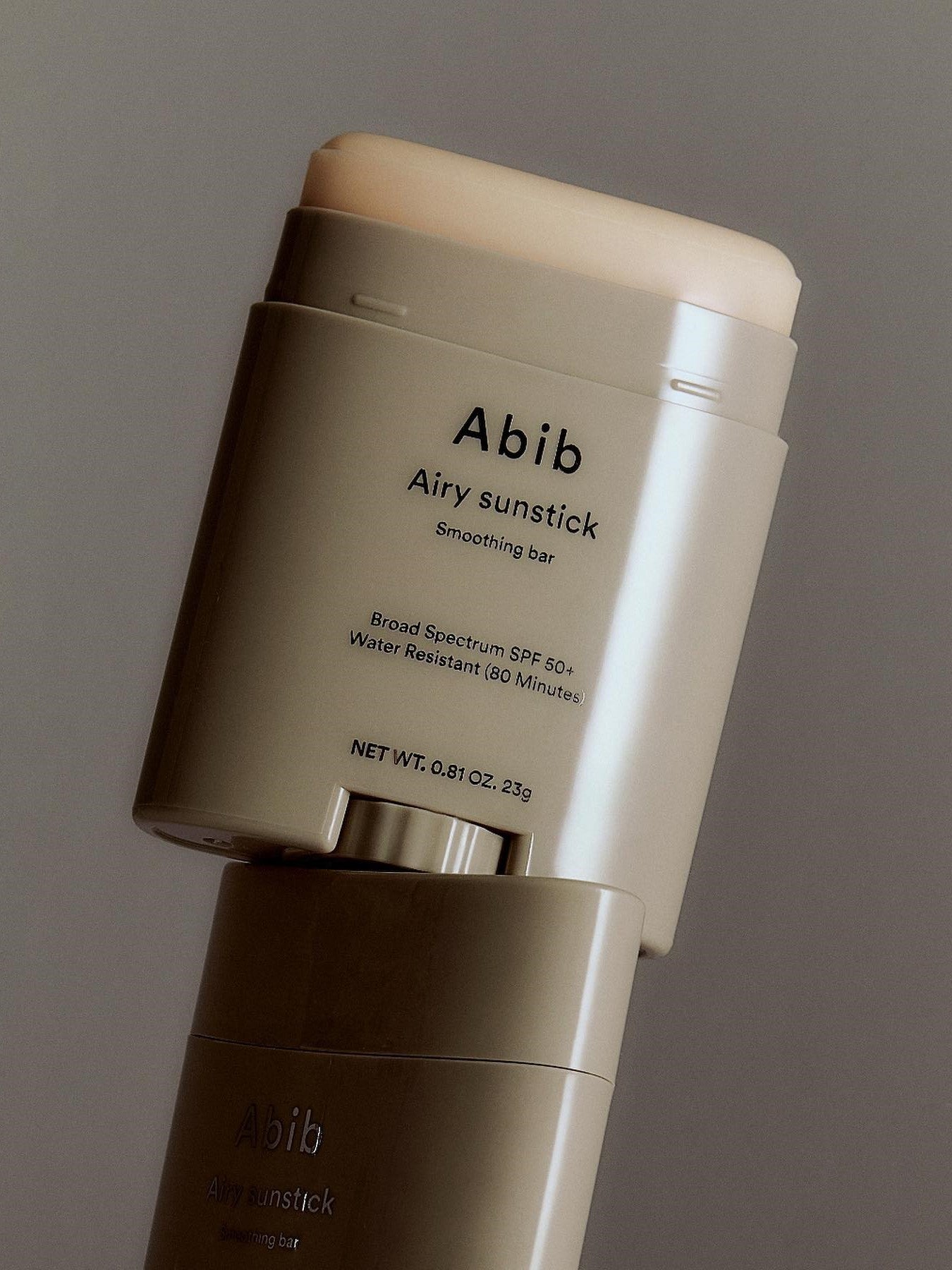 Close-up of the Abib Airy Sunstick, a waterproof SPF 50+ sunscreen stick in sleek taupe packaging designed for easy application.