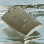 The Abib Airy Sunstick, a sleek beige sunscreen stick, floating on water with glistening droplets, highlighting its waterproof formula.