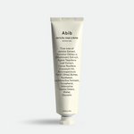 A white tube of Abib Jericho Rose Crème, showcasing ingredient details and minimalist branding, displayed against a light gray background.