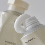 Close-up of two Abib Jericho Rose Crème tubes with white caps; one nozzle visible, showcasing matte and glossy textures under soft lighting.