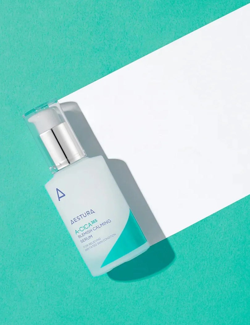 A bottle of Aestura A-Cica 365 Blemish Calming Serum on a vibrant turquoise background, next to a white paper sheet.