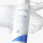A bottle of Aestura Atobarrier 365 Hydro Essence with its milky texture splashing, highlighting its hydrating and skin-strengthening benefits.