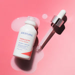 A bottle of Aestura Theracne 365 Active Serum with a dropper, resting on a soft pink surface, with serum pooling beneath.