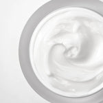 A close-up view of the smooth, creamy white texture of Anua Heartleaf Intense Calming Cream on a light background.