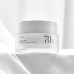 A white jar of Anua Heartleaf Intense Calming Cream, labeled with 70% Heartleaf, resting on a soft, textured white surface.